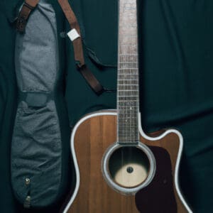 An image showcasing the Fender FA-125 Dreadnought Guitar Bundle, capturing the rich mahogany finish of the guitar, the elegant soundhole rosette, the sturdy construction, and the included accessories like picks, strap, and gig bag