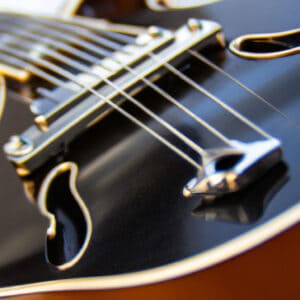 the essence of the Gretsch Boxcar Guitar in a captivating image: a close-up shot of the sleek, vintage-inspired body, showcasing the rich tobacco sunburst finish and intricate F-holes, with the strings elegantly reflecting the light
