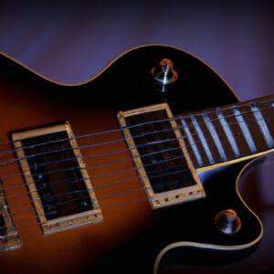 An image capturing the rich mahogany body of the Ibanez PF1512, showcasing its glossy finish and elegant curves, with the striking contrast of the 12 steel strings gleaming under warm studio lights