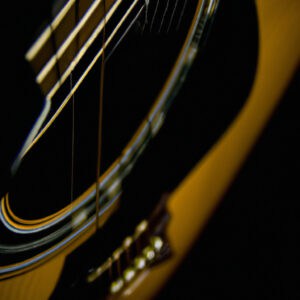 An image showcasing the elegant curves of the Yamaha F310, capturing its glossy natural-finished body and contrasting dark fretboard