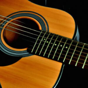 An image showcasing the Yamaha FG800, a sleek and glossy acoustic guitar with a solid spruce top, rosewood fingerboard, and chrome hardware, captivating viewers with its rich, warm tones and impeccable craftsmanship