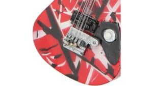 High-quality electric guitar featuring a bold red and black abstract pattern, guitar bridge, and strings detail, perfect for musicians and collectors.